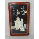 A Chinese white metal picture, depicting a gentleman and his partner underneath a prunus tree with