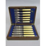 An oak cased canteen of fish cutlery with bone handles and silver fittings, maker GH, Sheffield