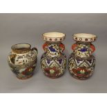 A pair of Japanese polychrome vases with elephant head and ring handles and bird and floral