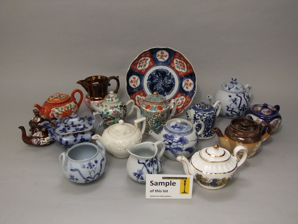 A collection of oriental and other teapots including a blue and white example, famille rose example,