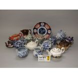 A collection of oriental and other teapots including a blue and white example, famille rose example,