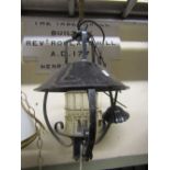 A hanging ironwork ceiling light with simple scroll detail and mottled plafonnier shade, together