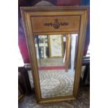 A gilt framed wall mirror of rectangular form with bevelled edge plate and classical detailing,