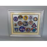 A framed collection of stitched Apollo and Nasa badges, 14 in total, 46 x 55 cm