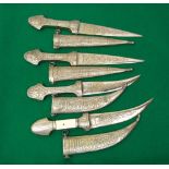 Four Arabic style daggers with plated finish, repeating detailed decoration and scripted panels