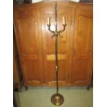 A cast brass three branch standard lamp with stylised dolphin, reeded column and weighted disc