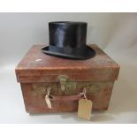 A good quality leather travelling trunk with straps containing a Wheeler & Company top hat