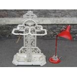 A late Victorian cast iron two divisional umbrella stand, the raised back with decorative stylised