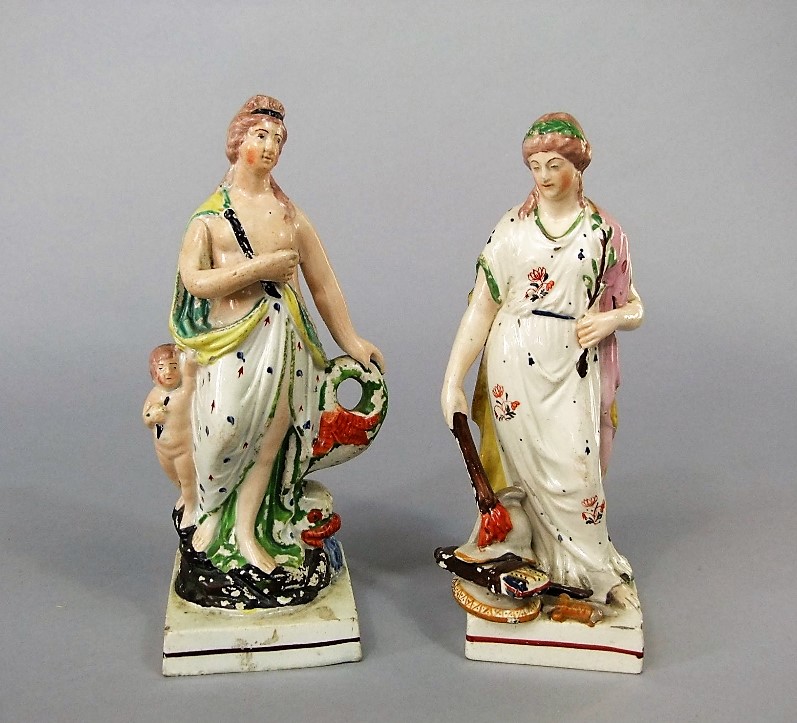 A pair of early 19th century Staffordshire classical allegorical female figures, both raised on