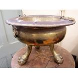 A 19th century or earlier brass brazier, of circular form raised on three stout claw and ball