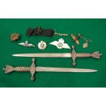 A pair of German naval letter knives in the form of daggers, spitfire brooch, RAF lapel badge, and