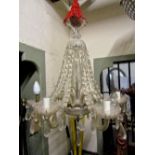 A hanging six branch glass chandelier with vase shaped stem, trumpet finial and trailing prism