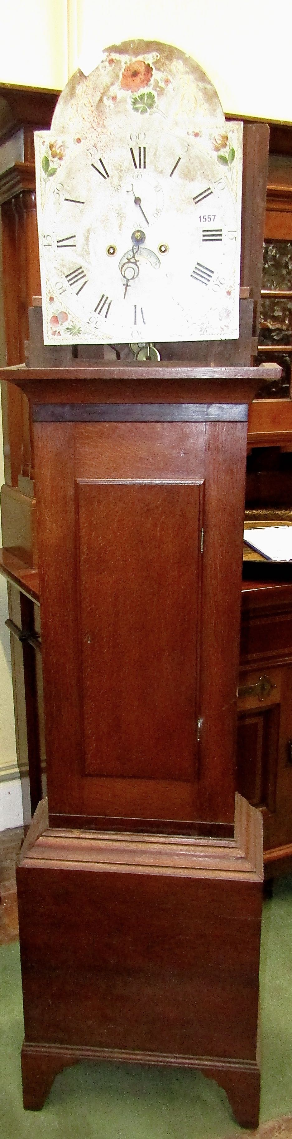 A Georgian oak longcase clock (lacks hood) enclosing a broken arch painted dial with floral