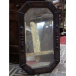 A pair of Edwardian/1920s oak framed wall mirrors of elongated octagonal form with applied split