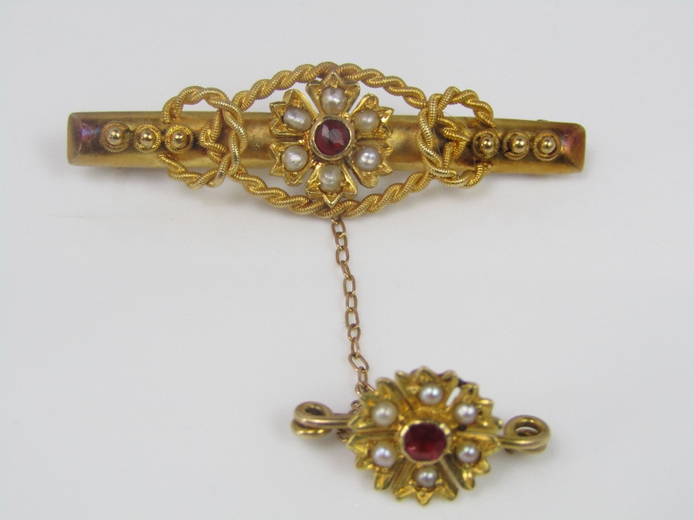 A good quality almandine garnet and seed pearl brooch of floral design with rope twist border
