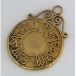 Eastern pendant in unmarked 24ct gold, applied with various Arabic symbols and scrolled bale