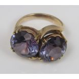 An amethyst coloured two stone ring in unmarked yellow metal, size P, 11.5g