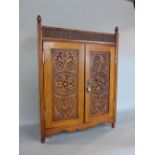 Early 20th century oak arts and crafts smokers cabinet, with Tudor rose band over twin doors