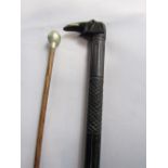 African ebony walking cane, the crook in the form of an elephants head together with a further