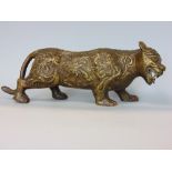 An interesting eastern bronze study of a tiger, with applied scrolled floral decoration, 25cm long