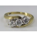 An 18ct three stone diamond crossover ring, central diamond 0.25cts approx, size M, 4.2g