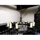 An Old English style hanging ceiling light of hooped form supporting twelve torch sconces with