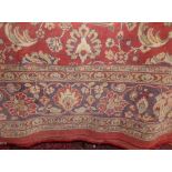 A Belgian cotton carpet in the Persian style with floral detail within running borders
