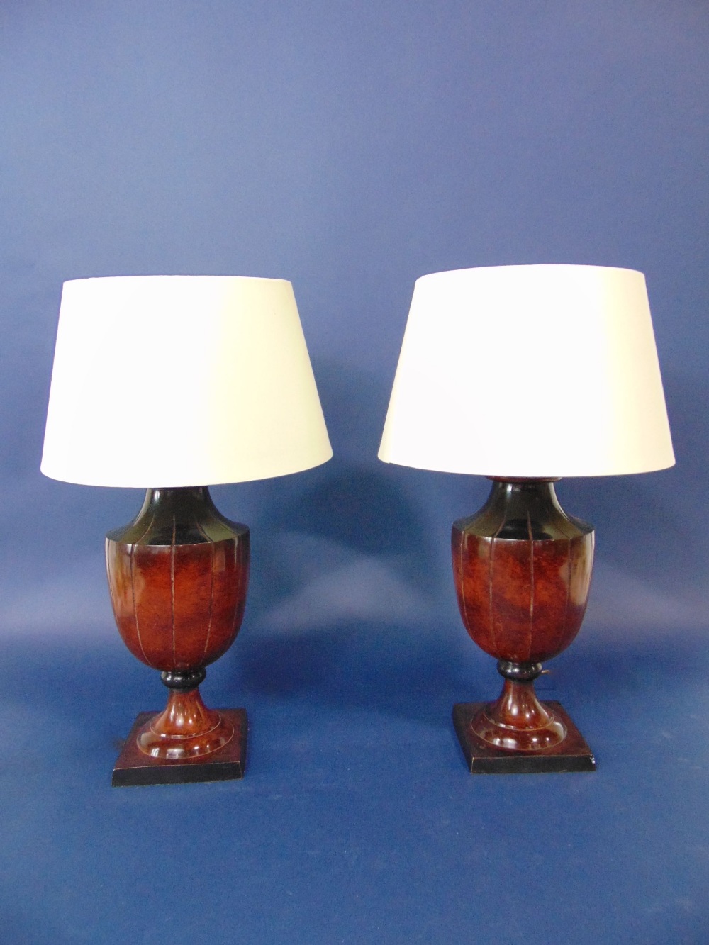 Pair of bronzed faceted baluster table lamps, upon stepped square bases, 43cm high (with shades)