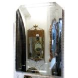An Art Deco style frameless wall mirror of rectangular form with canted top corners and geometric