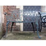 A small decorative cast iron one to two seat garden bench with shaped outline and pierced scrolled