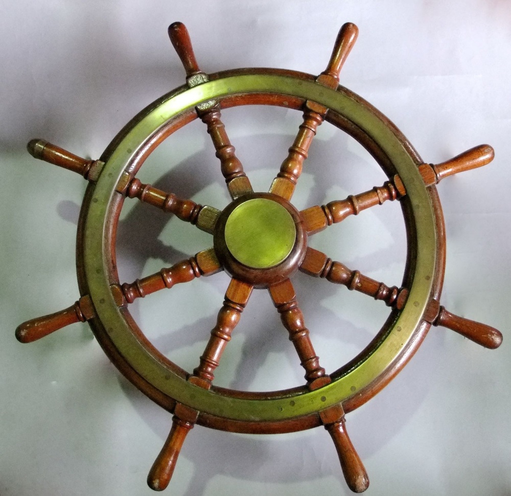 Teak and brass ships wheel, with eight turned handles around a central brass roundel, 78 cm