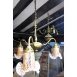 A three branch brass hanging ceiling light with tapered stem and central bun support, mottled