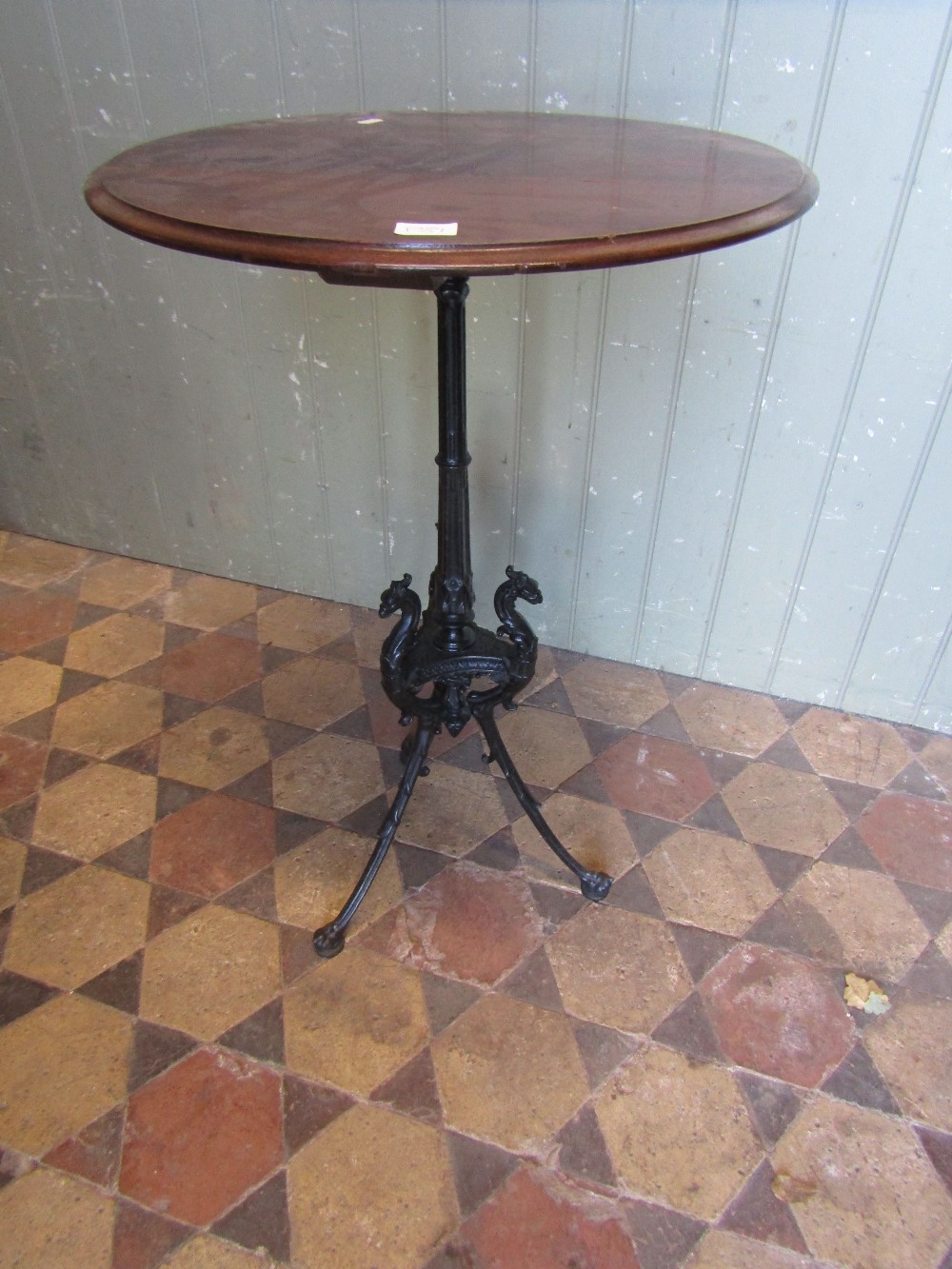 A Victorian cast iron table base with fluted column and swept tripod supports with dragons head