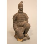 A 19th century oriental terracotta model of a kneeling warrior, 18cm tall approx