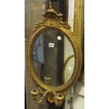 A 19th century gilt framed girandole of oval form with moulded shell and further detail, two