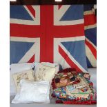 Two vintage union jacks together with a further quantity of fabric and textiles