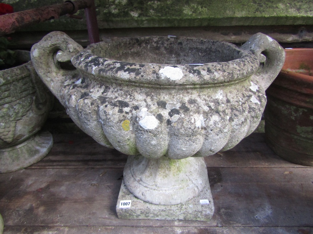 A good quality weathered cast composition stone campana shaped garden urn with scrolled loop