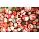 A collection of antique glass marbles with white and orange swirl detail, 25mm diameter and smaller