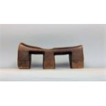 Tribal Interest - A carved hardwood head rest with three cut supports