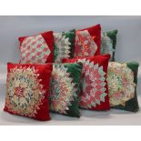 Eight cushions in co-ordinating red and green velvets, each with a patchwork pattern on one side