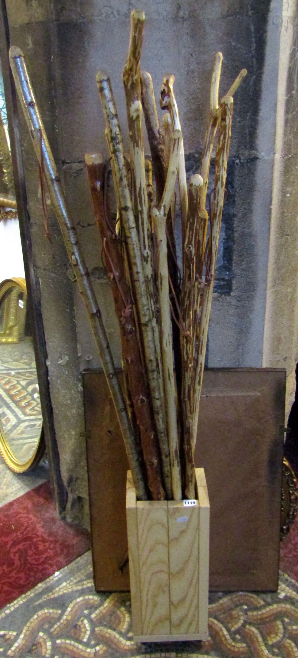 A bundle of eighteen rustic walking sticks housed within a contemporary stand