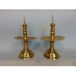 A good pair of early cast brass cricket candlesticks with drip trays, 27cm high (2)