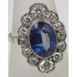 An impressive sapphire and diamond ring, the sapphire 11 x 8mm approx within a diamond set scalloped