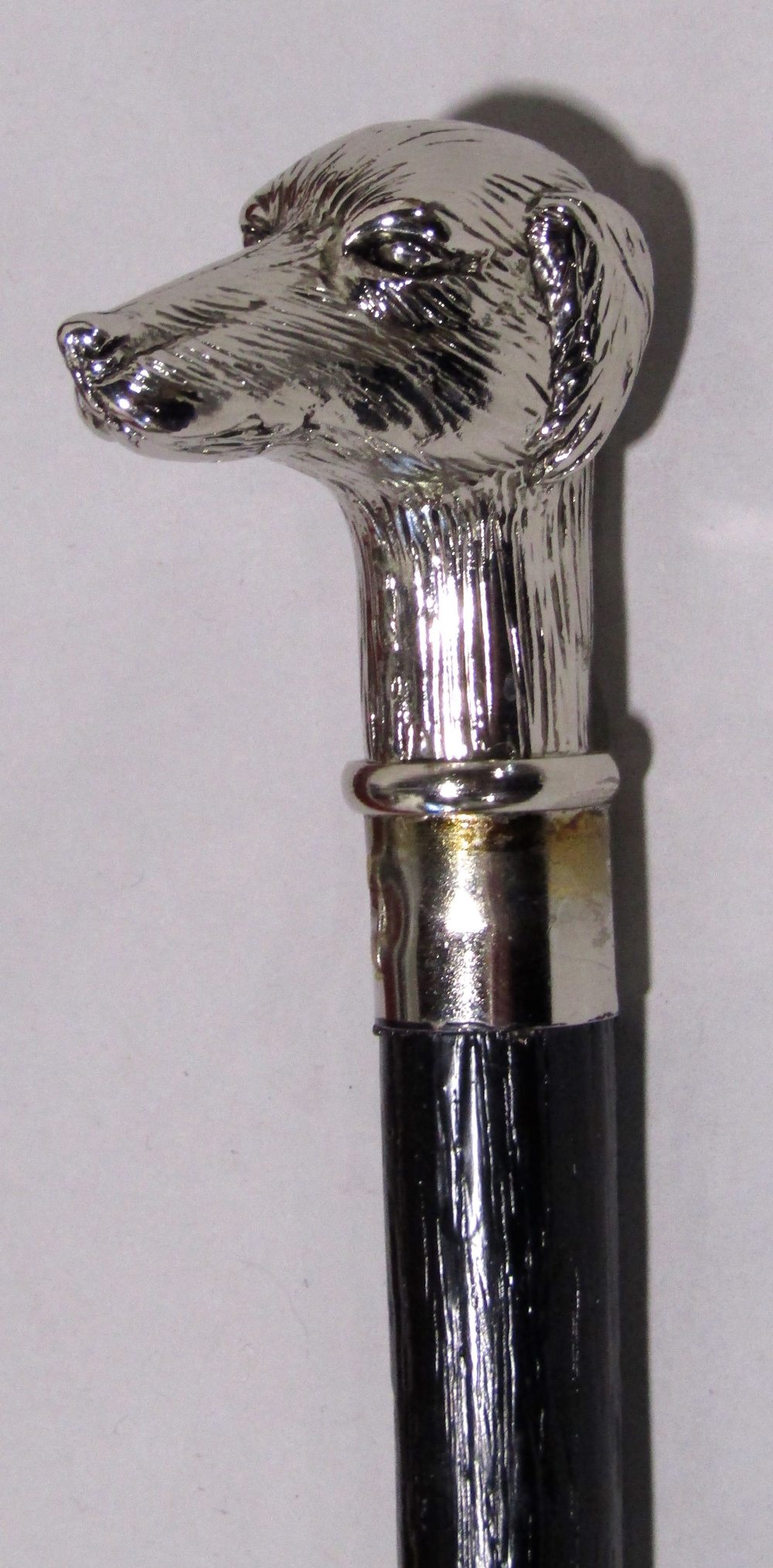 Ebonised walking stick with cast white metal dog head finial