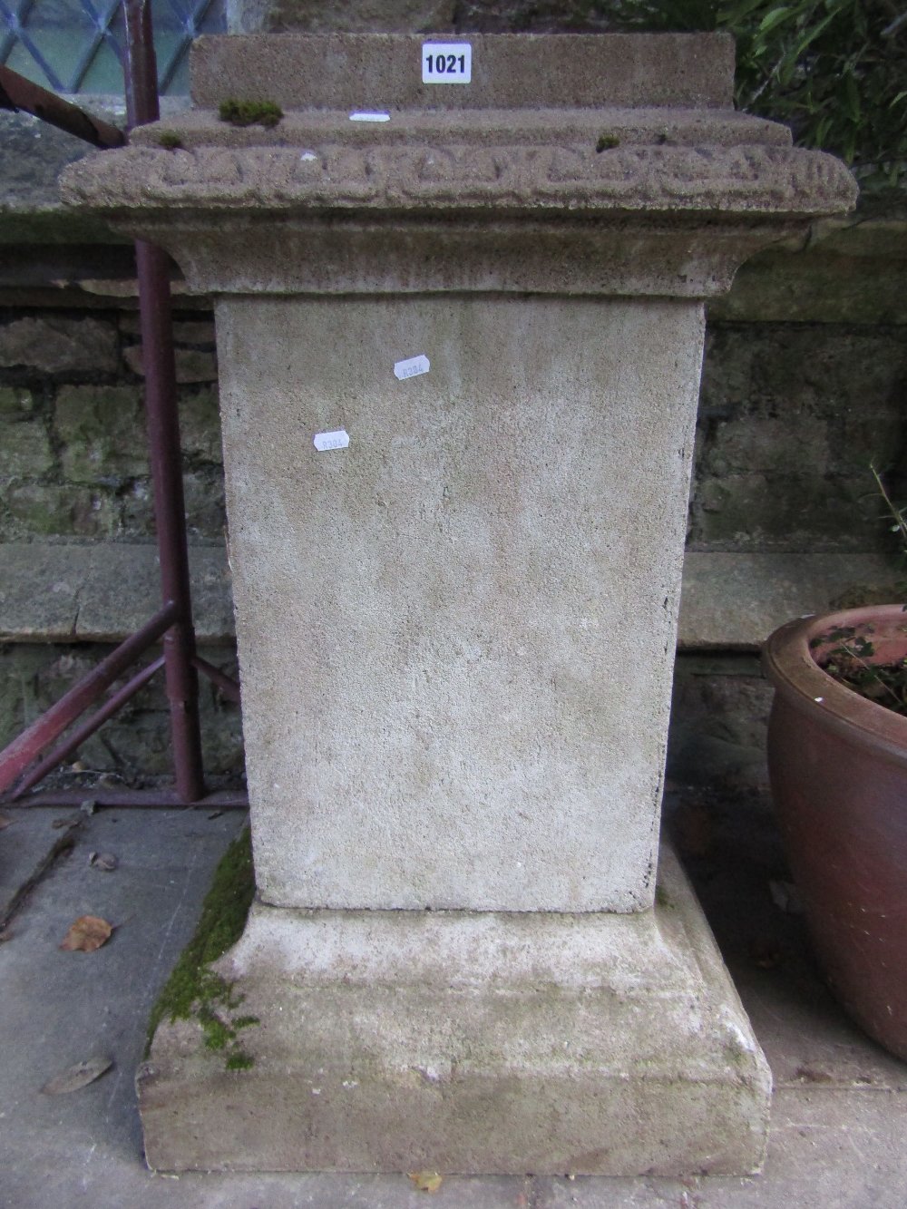 A weathered cast composition stone three sectional garden planter with stepped top, square section