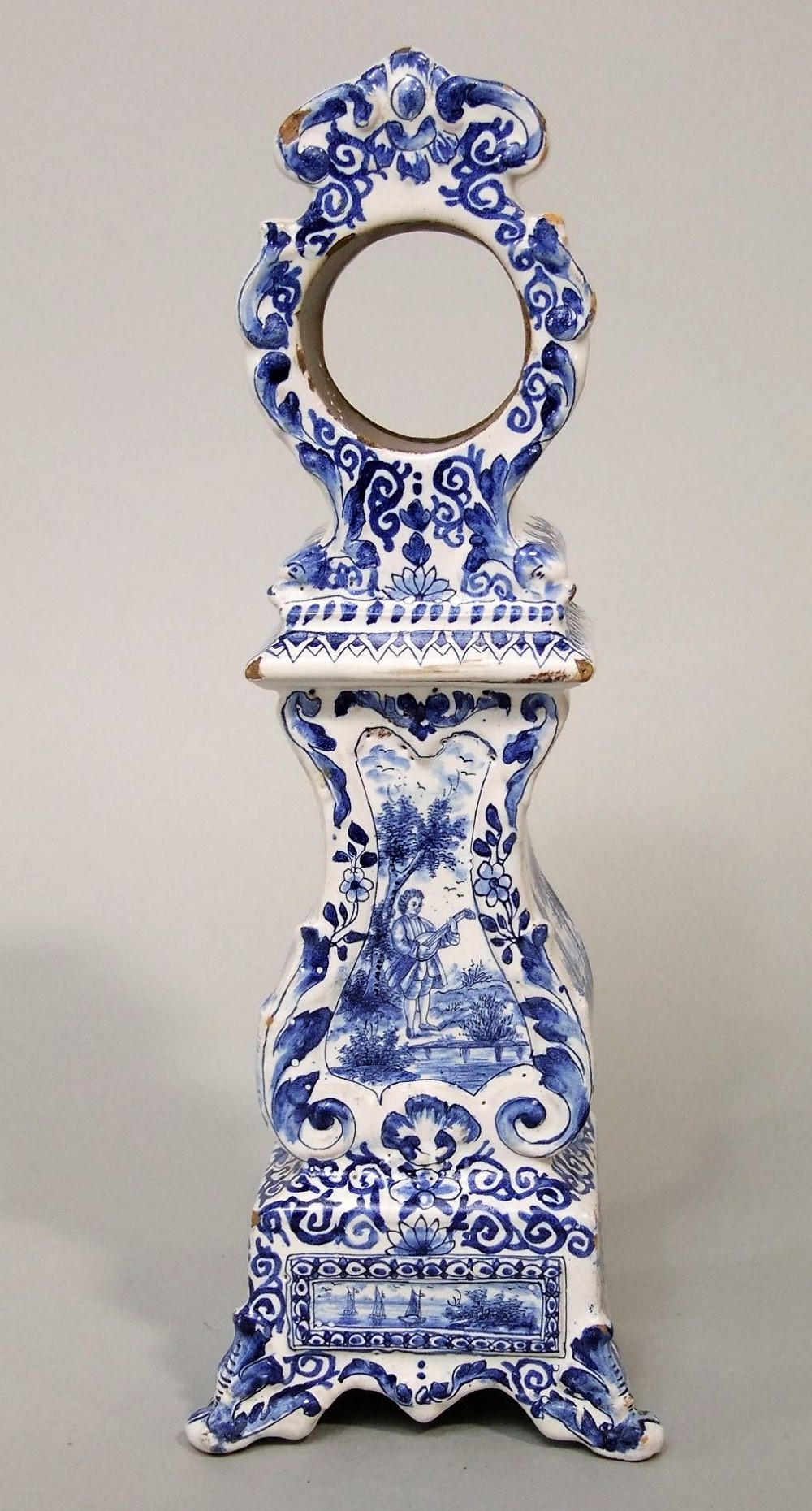 A late 19th century tin glazed earthen ware Delft type watch case in the form of a longcase clock,