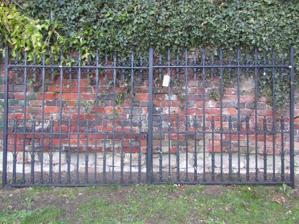 A pair of good quality heavy iron work entrance gates with vertical rails and scroll detail, 10ft