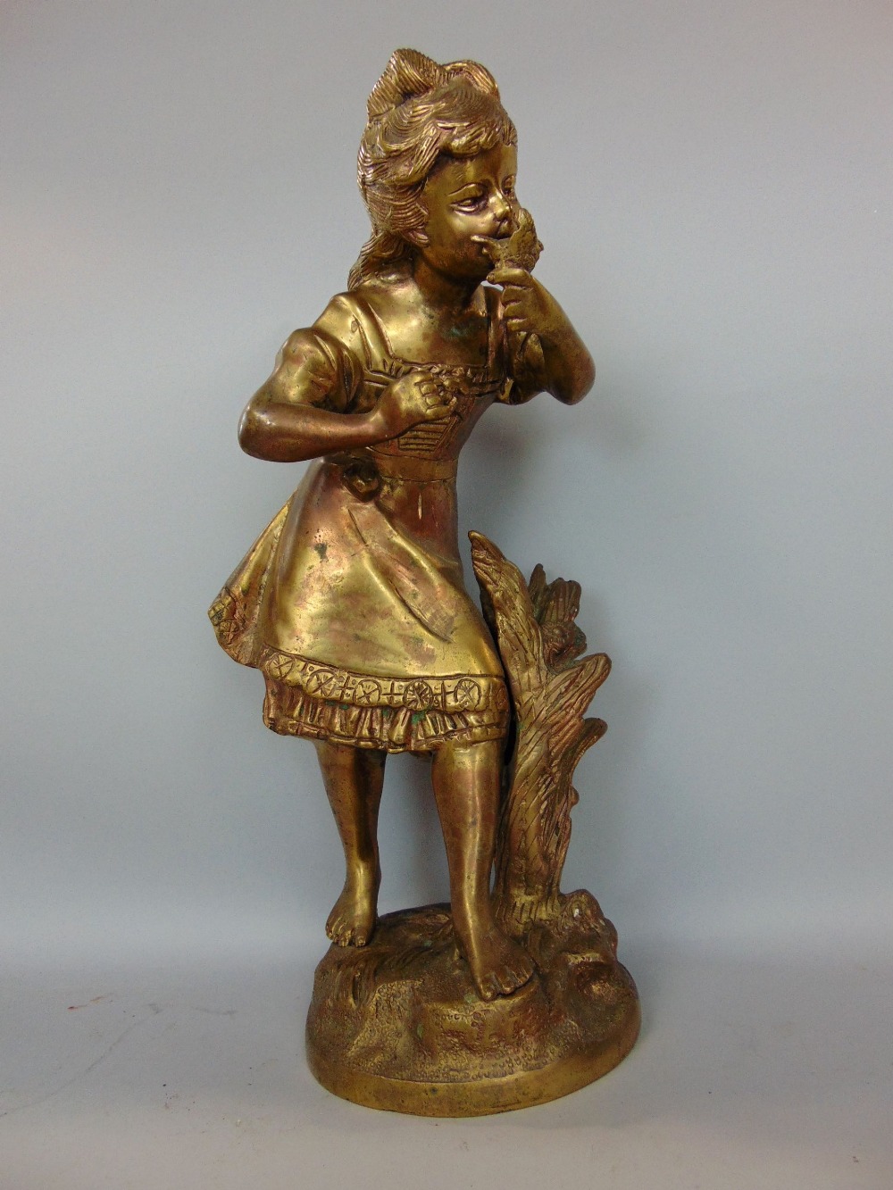 Gilt bronze study of a standing girl holding a bird, 40cm high