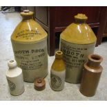 Two vintage stoneware flagons with printed merchants labels J Booth late Booth Bros botanical