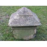 A weathered carved natural stone pillar cap of square form with stepped pyramid top